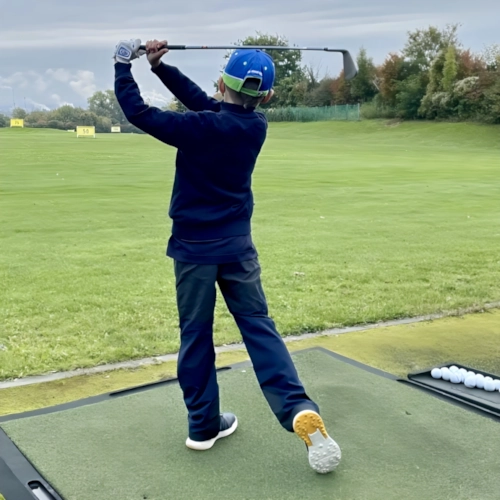 Golfkid beim Training auf der Driving Range Golfkid beim Training auf der Driving Range